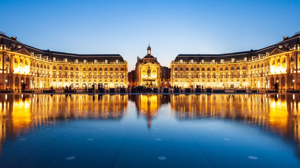 Classic architectural facade of Place de la Bourse reflecting in the Miroir d eau water mirror in Bordeaux France.